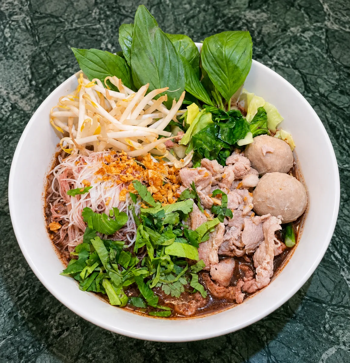 Guay teow nam tok de Thai Yim 2 : soupe de nouilles, viande, boulettes, pousses de soja et herbes fraîches
