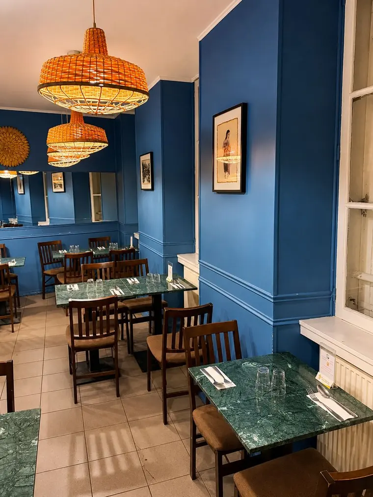 Salle aux murs bleus et tables en marbre vert de Thai Yim 2